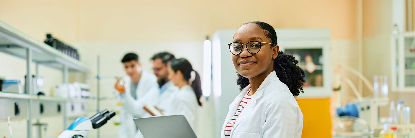 science lab with african american student holding a laptop